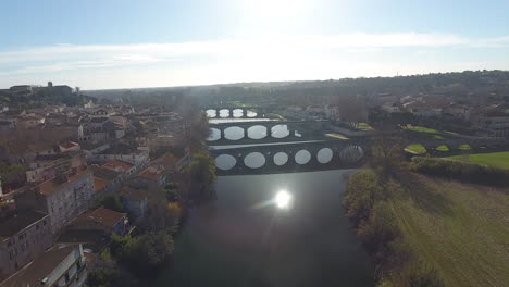 Sonnenreflexion-über-Dem-Fluss-Orb-Mit-Brücken-In-Beziers,-Frankreich,-Drohnen-Luftaufnahme